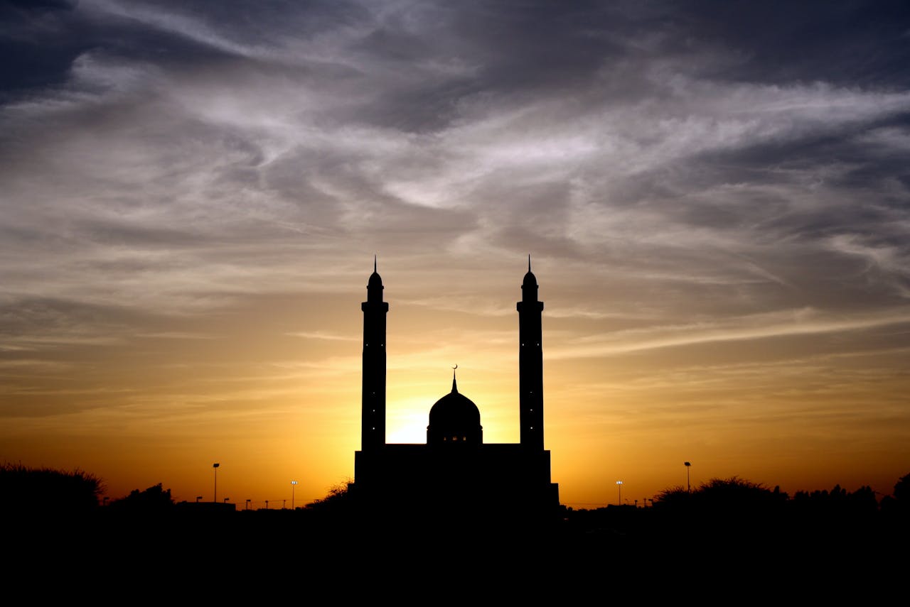 Beautiful silhouette of a mosque against a vibrant sunset sky, highlighting its architectural elegance.